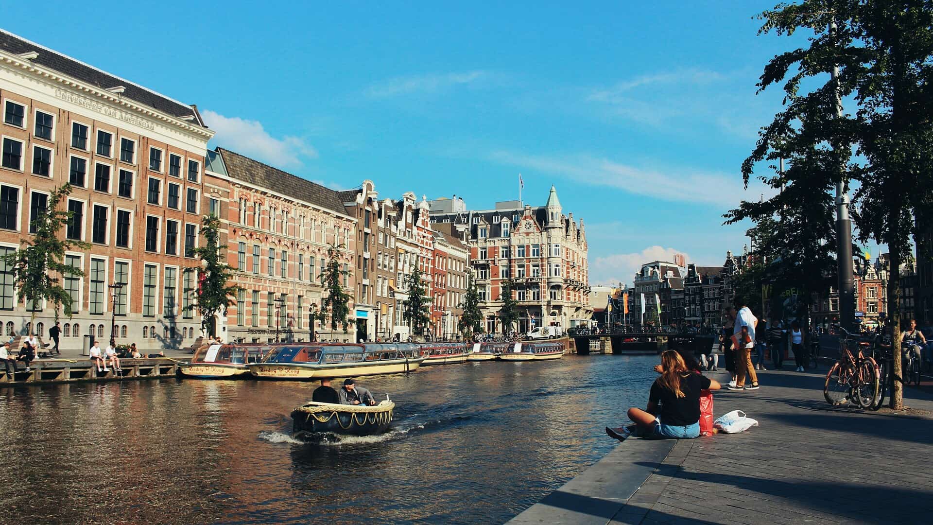 Tourists and canal boats in central Amsterdam amid debate over the city's planned tourist tax increase.
